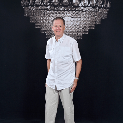 1 Downtown Dave Schafer posing for a photo with a chandelier backdrop.