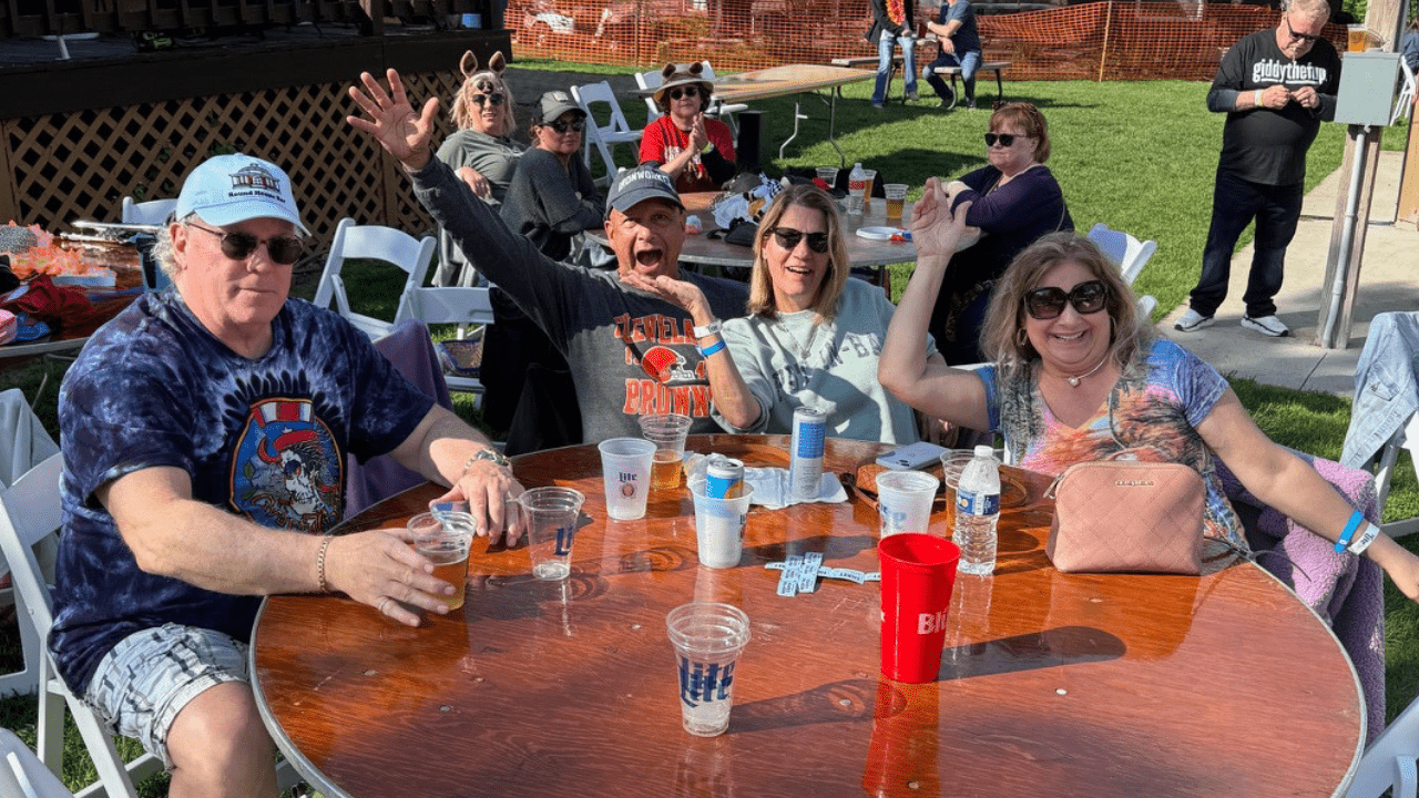 3 People posing for a picture at their table at Spring Fling at the Island Club pavilion.
